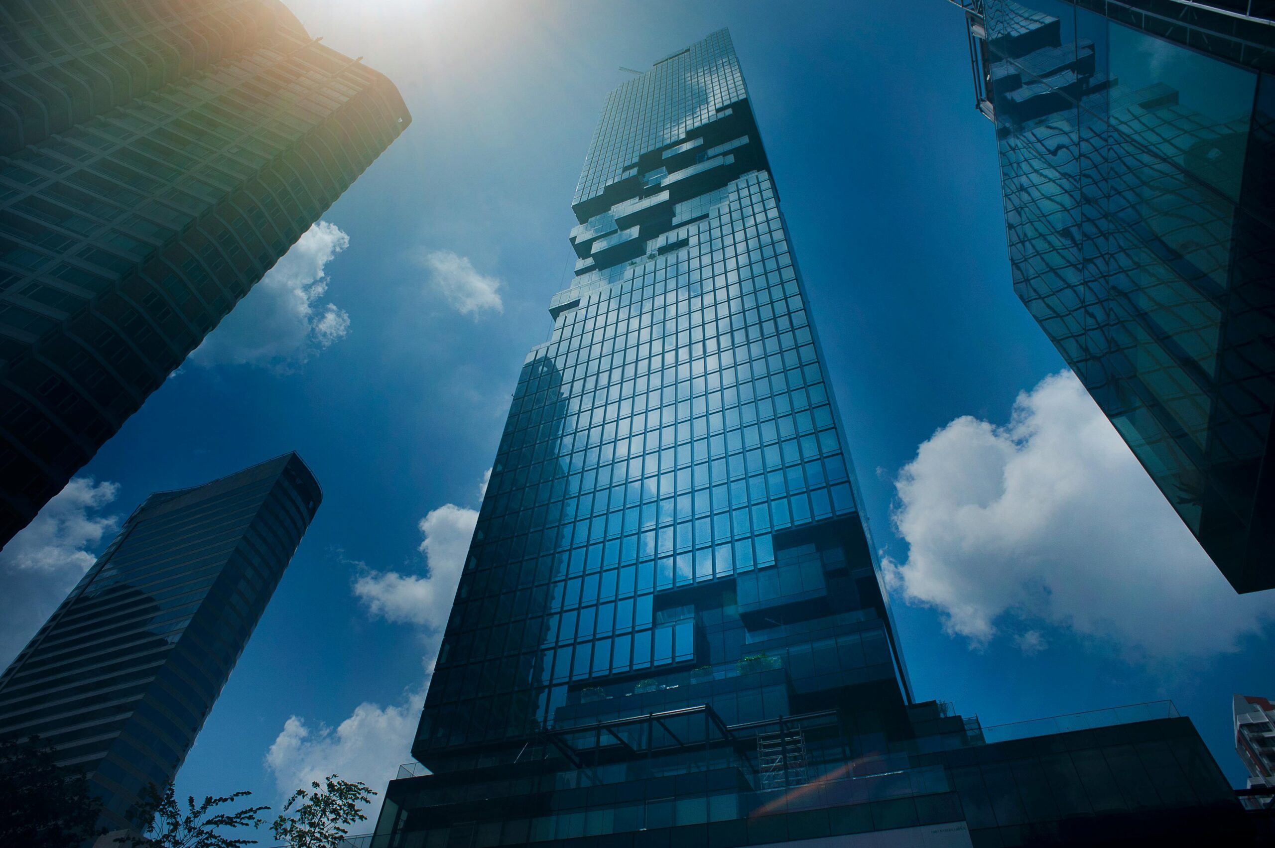 Dramatic view of modern skyscrapers amidst clouds in Bangkok, Thailand.